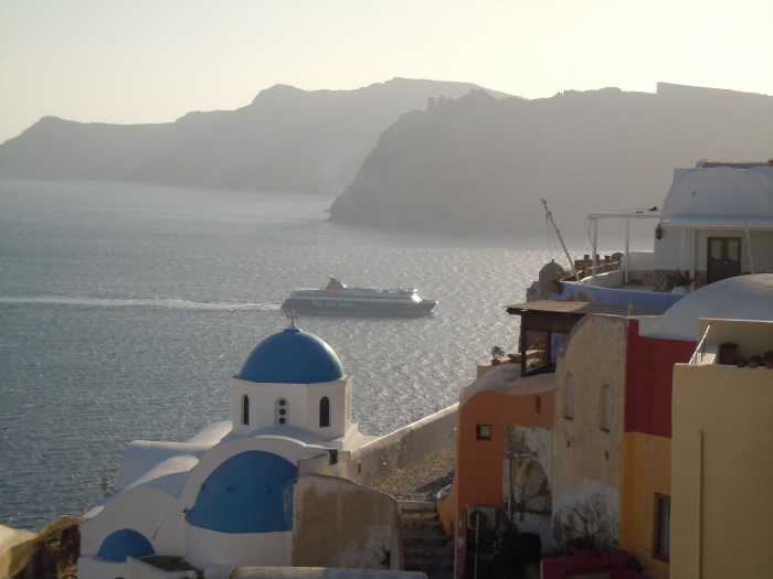 Blaue Kirchenkuppel und weiße Häuser über der Caldera von Santorini